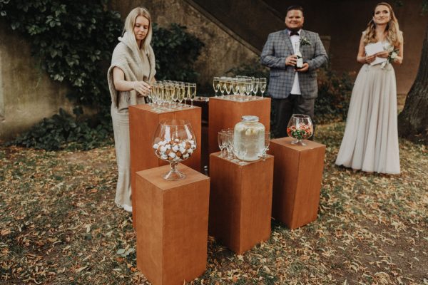 Šampano staliukas ant rudų kolonų